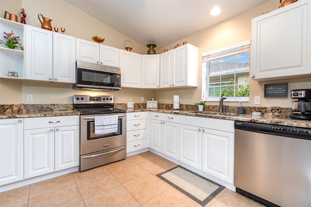 1626 Terra Ceia Bay Cir Unit 1626, Palmetto, FL 34221 - kitchen featuring appliances with stainless steel finishes, vaulted ceiling, white cabinets, dark stone countertops, and open shelves