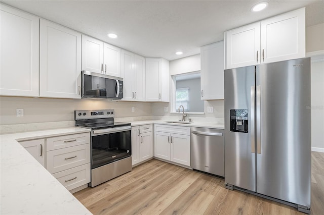 314 Circle Dr, Palm Harbor, FL 34683 - kitchen featuring stainless steel appliances, light wood-style flooring, white cabinetry, and recessed lighting