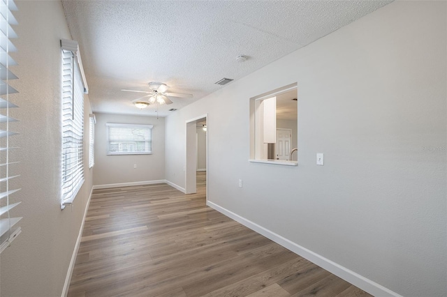 314 Circle Dr, Palm Harbor, FL 34683 - unfurnished room with ceiling fan, wood finished floors, a textured ceiling, and a smoke detector