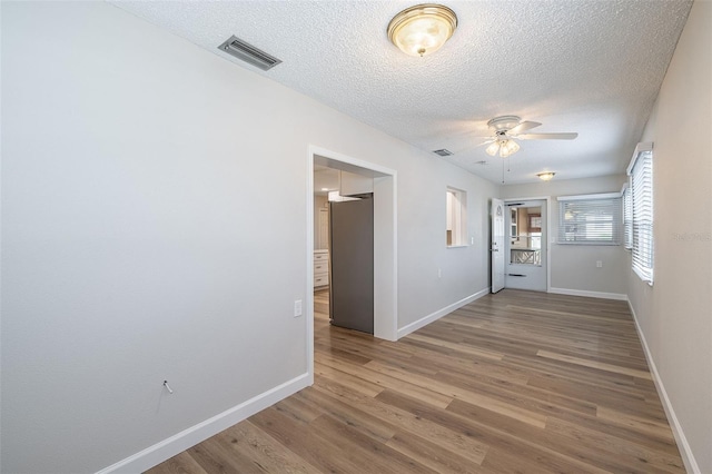 314 Circle Dr, Palm Harbor, FL 34683 - unfurnished room featuring ceiling fan, a textured ceiling, and wood finished floors