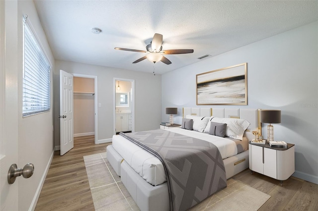 314 Circle Dr, Palm Harbor, FL 34683 - bedroom featuring light wood-type flooring, a ceiling fan, and connected bathroom