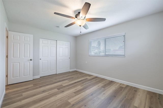 314 Circle Dr, Palm Harbor, FL 34683 - unfurnished bedroom with a closet, light wood-style flooring, and a ceiling fan