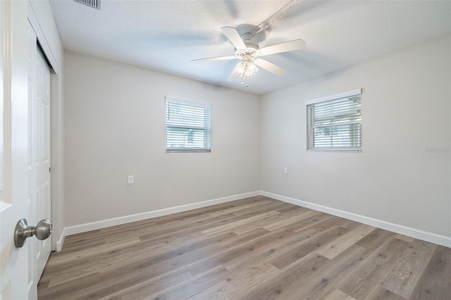 314 Circle Dr, Palm Harbor, FL 34683 - unfurnished bedroom with a closet, light wood-type flooring, a ceiling fan, and a textured ceiling