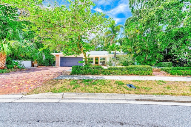 1578 Druid Rd S, Belleair, FL 33756 - obstructed view of property with decorative driveway and an attached garage
