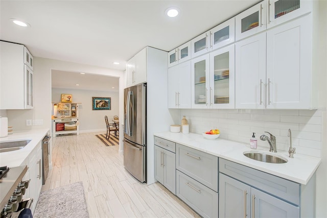 1578 Druid Rd S, Belleair, FL 33756 - kitchen with appliances with stainless steel finishes, tasteful backsplash, recessed lighting, light countertops, and glass insert cabinets