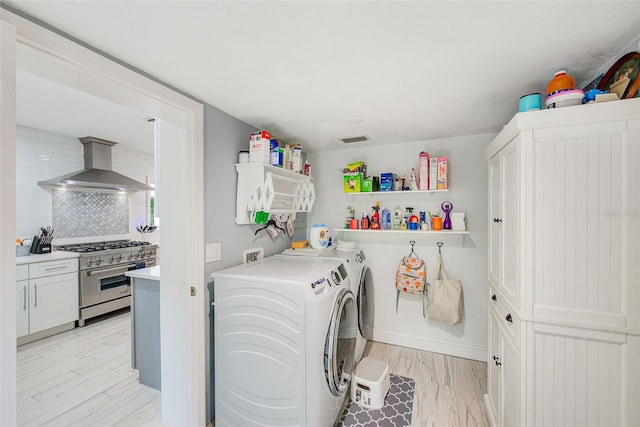 1578 Druid Rd S, Belleair, FL 33756 - washroom featuring washing machine and dryer and light wood-type flooring
