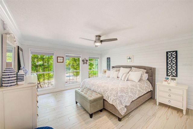 1578 Druid Rd S, Belleair, FL 33756 - bedroom with crown molding, light wood-type flooring, a ceiling fan, and wood walls
