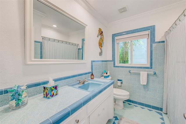 1578 Druid Rd S, Belleair, FL 33756 - full bathroom with tile walls, tile patterned flooring, vanity, crown molding, and a wainscoted wall