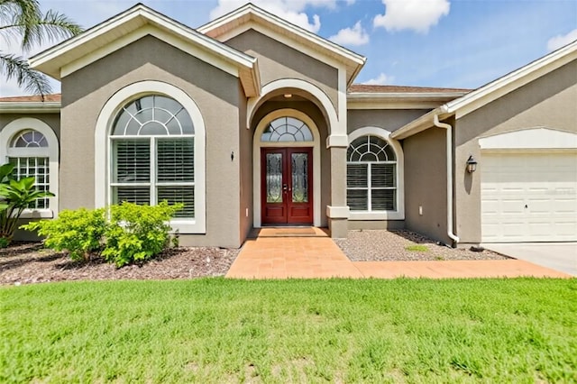 9126 Cypress Keep Ln, Odessa, FL 33556 - property entrance featuring french doors, an attached garage, stucco siding, and a lawn