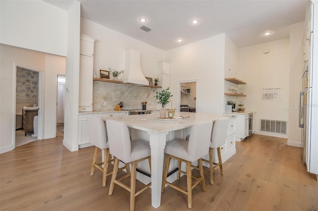 9126 Cypress Keep Ln, Odessa, FL 33556 - kitchen featuring open shelves, custom exhaust hood, white cabinetry, a kitchen breakfast bar, and recessed lighting
