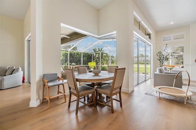 9126 Cypress Keep Ln, Odessa, FL 33556 - dining room with a sunroom, light wood-style flooring, recessed lighting, ceiling fan, and a towering ceiling