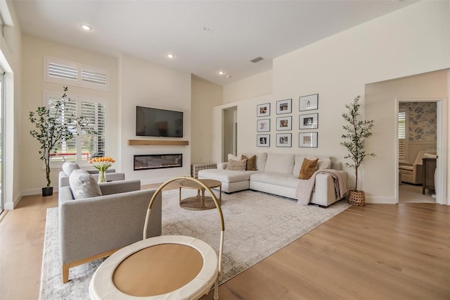 9126 Cypress Keep Ln, Odessa, FL 33556 - living room with light wood finished floors, plenty of natural light, a glass covered fireplace, recessed lighting, and a high ceiling