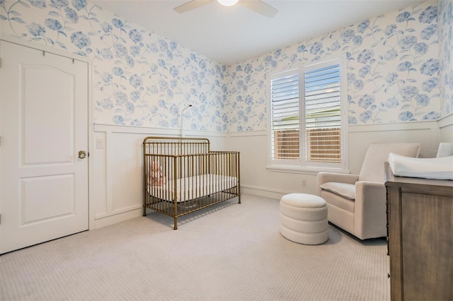 9126 Cypress Keep Ln, Odessa, FL 33556 - bedroom featuring wainscoting, wallpapered walls, a crib, carpet flooring, and ceiling fan