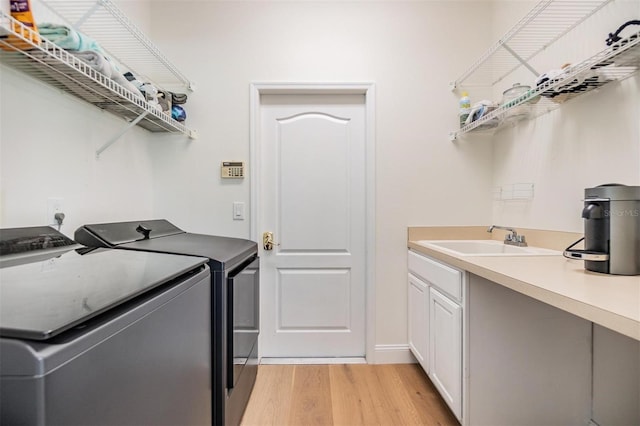 9126 Cypress Keep Ln, Odessa, FL 33556 - laundry room featuring washer and dryer, light wood-type flooring, and cabinet space