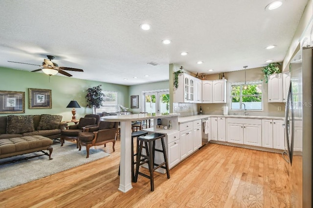 3304 W Harbor View Ave, Tampa, FL 33611 - kitchen with a peninsula, appliances with stainless steel finishes, open floor plan, a breakfast bar, and light wood-style floors
