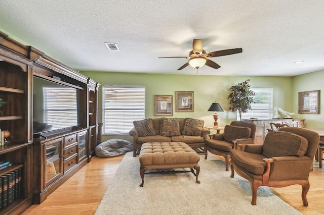 3304 W Harbor View Ave, Tampa, FL 33611 - living area with a ceiling fan, light wood-style flooring, and a textured ceiling