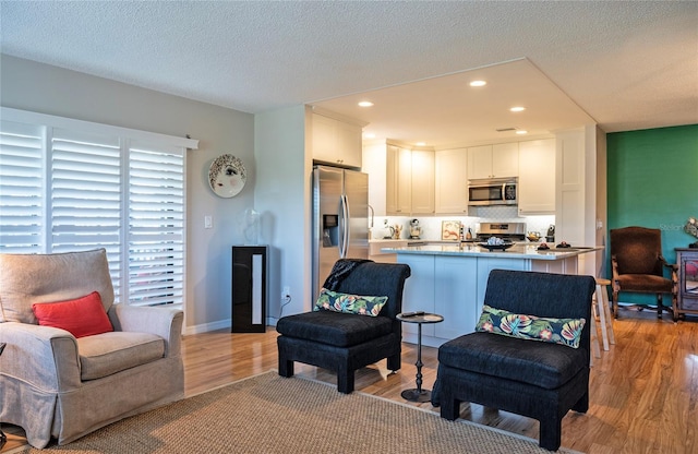 7941 58th Ave N Unit 301, Saint Petersburg, FL 33709 - living area featuring light wood-type flooring, a textured ceiling, and recessed lighting