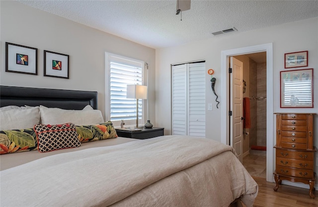 7941 58th Ave N Unit 301, Saint Petersburg, FL 33709 - bedroom featuring wood finished floors, a closet, a textured ceiling, and ceiling fan