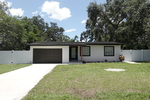 814 W 131st Ave, Tampa, FL 33612 - view of front facade with an attached garage, driveway, stucco siding, and a gate