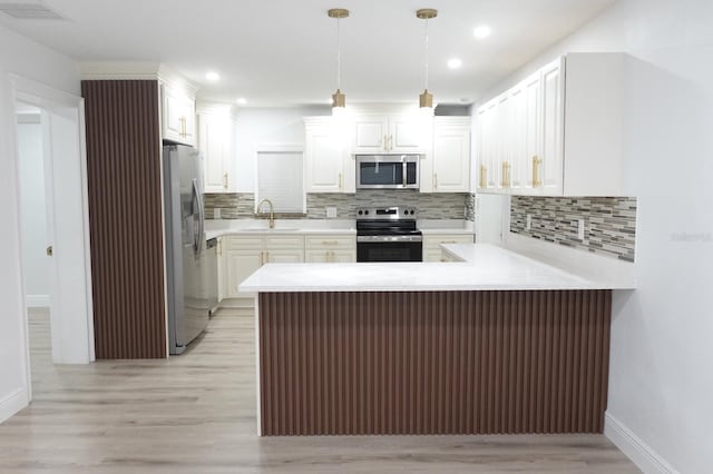 814 W 131st Ave, Tampa, FL 33612 - kitchen with appliances with stainless steel finishes, a peninsula, light wood-style floors, white cabinetry, and light countertops
