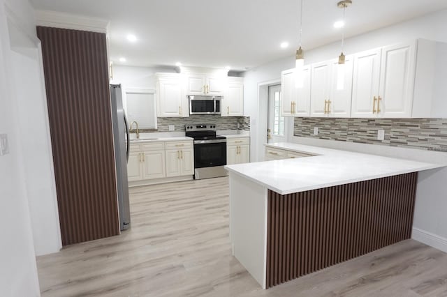 814 W 131st Ave, Tampa, FL 33612 - kitchen with stainless steel appliances, a peninsula, light wood finished floors, tasteful backsplash, and white cabinetry