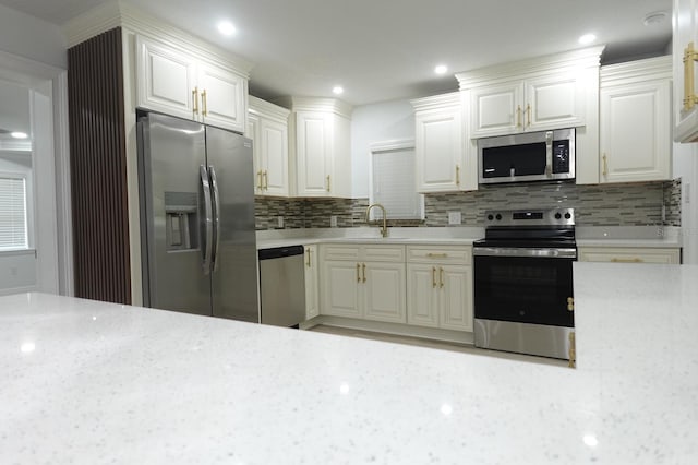 814 W 131st Ave, Tampa, FL 33612 - kitchen featuring stainless steel appliances, tasteful backsplash, white cabinetry, light stone countertops, and recessed lighting
