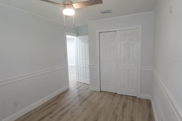 814 W 131st Ave, Tampa, FL 33612 - unfurnished bedroom featuring light wood finished floors, a closet, ornamental molding, and a ceiling fan