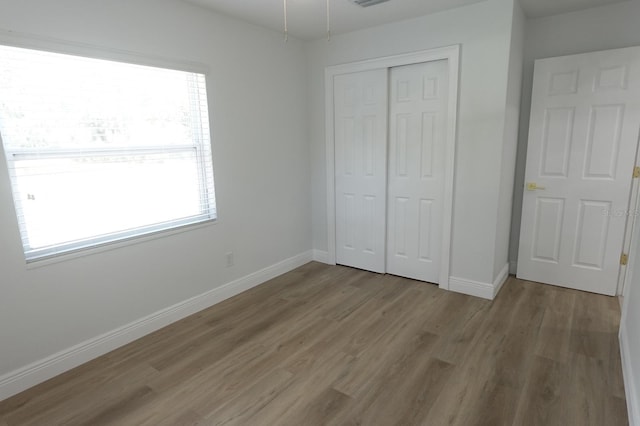 814 W 131st Ave, Tampa, FL 33612 - unfurnished bedroom with light wood-type flooring, multiple windows, and a closet