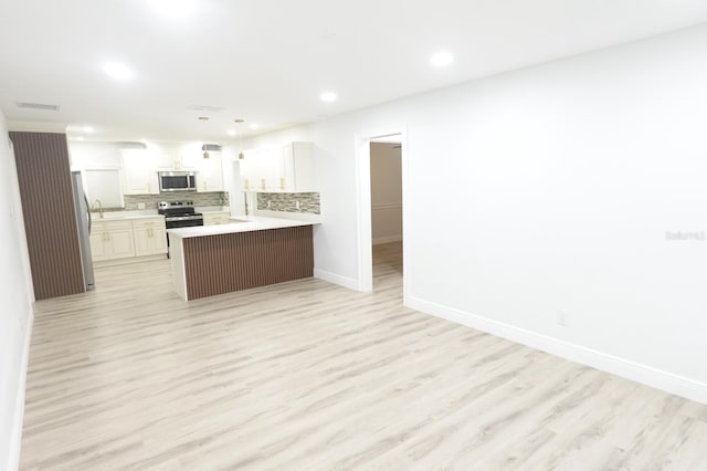 814 W 131st Ave, Tampa, FL 33612 - kitchen with stainless steel appliances, decorative backsplash, a peninsula, light wood-style floors, and recessed lighting