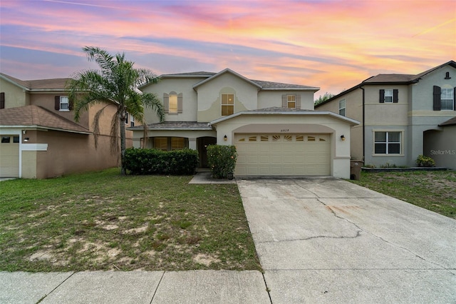 16828 N Gold Star Ct, Clermont, FL 34714 - view of front of home featuring an attached garage, stucco siding, driveway, and a front yard