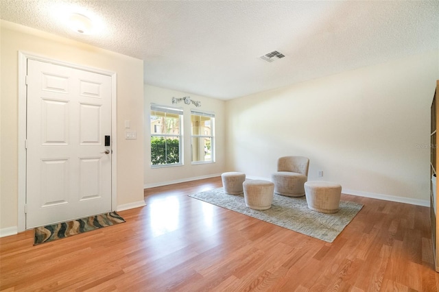 16828 N Gold Star Ct, Clermont, FL 34714 - entrance foyer with light wood-type flooring and a textured ceiling