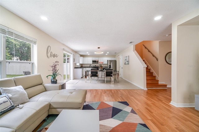 16828 N Gold Star Ct, Clermont, FL 34714 - living area with stairs, light wood-style flooring, recessed lighting, and a textured ceiling