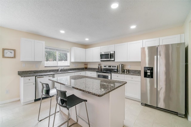 16828 N Gold Star Ct, Clermont, FL 34714 - kitchen featuring appliances with stainless steel finishes, dark stone counters, a breakfast bar, recessed lighting, and a kitchen island