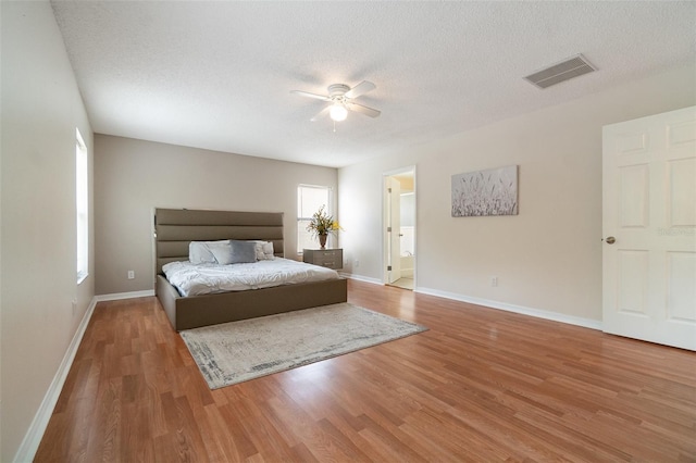 16828 N Gold Star Ct, Clermont, FL 34714 - bedroom with wood finished floors, a textured ceiling, a ceiling fan, and ensuite bathroom