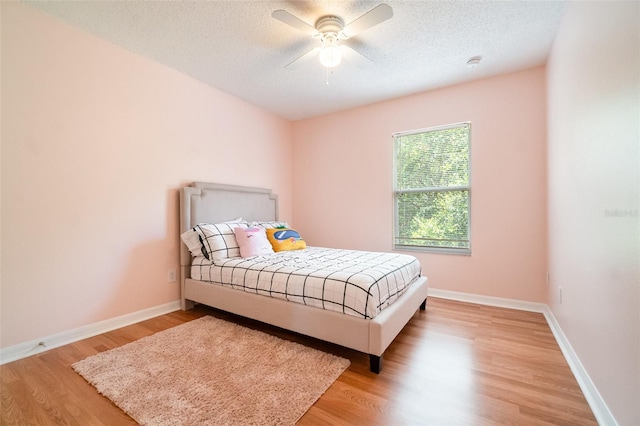 16828 N Gold Star Ct, Clermont, FL 34714 - bedroom featuring a textured ceiling, light wood-style flooring, and a ceiling fan