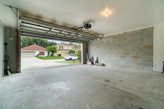 16828 N Gold Star Ct, Clermont, FL 34714 - garage featuring concrete block wall and a garage door opener