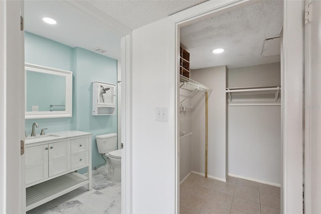14800 Walsingham Rd Unit 1215, Largo, FL 33774 - full bathroom with a walk in closet, vanity, a textured ceiling, and recessed lighting