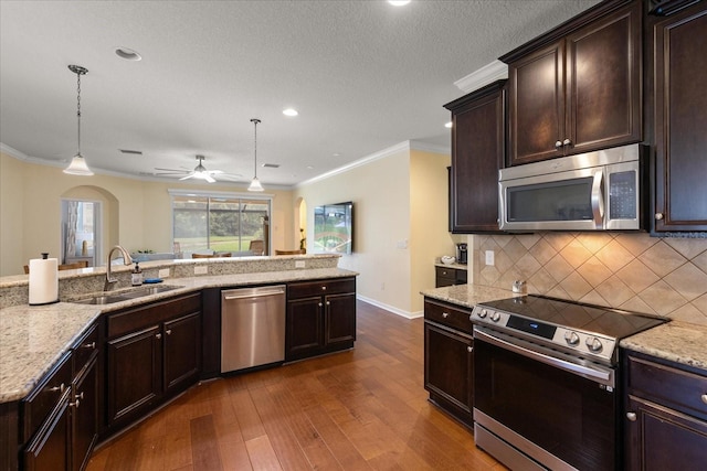 19409 Wingrove Ln, Lutz, FL 33558 - kitchen with appliances with stainless steel finishes, arched walkways, dark wood-type flooring, tasteful backsplash, and ceiling fan