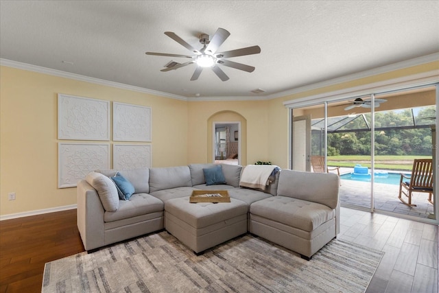 19409 Wingrove Ln, Lutz, FL 33558 - living room featuring ceiling fan, a sunroom, ornamental molding, wood finished floors, and arched walkways
