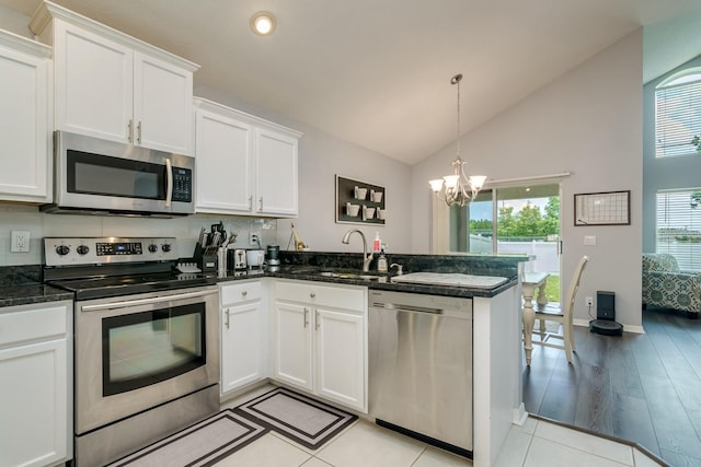 18508 Merseyside Loop, Land O Lakes, FL 34638 - kitchen featuring appliances with stainless steel finishes, a peninsula, white cabinets, a chandelier, and decorative light fixtures