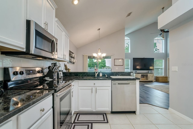 18508 Merseyside Loop, Land O Lakes, FL 34638 - kitchen featuring appliances with stainless steel finishes, a peninsula, a chandelier, white cabinetry, and high vaulted ceiling