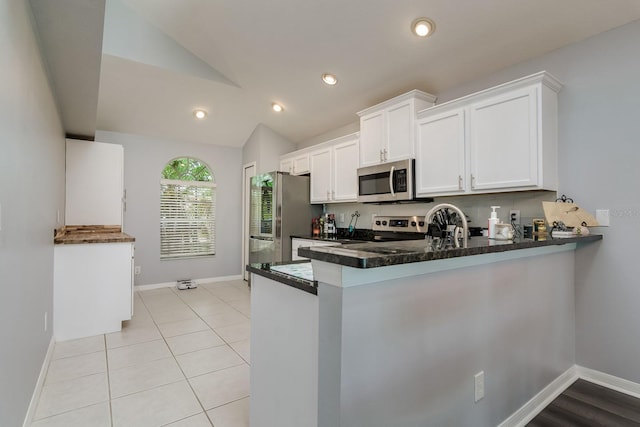 18508 Merseyside Loop, Land O Lakes, FL 34638 - kitchen with stainless steel appliances, lofted ceiling, white cabinets, a peninsula, and recessed lighting