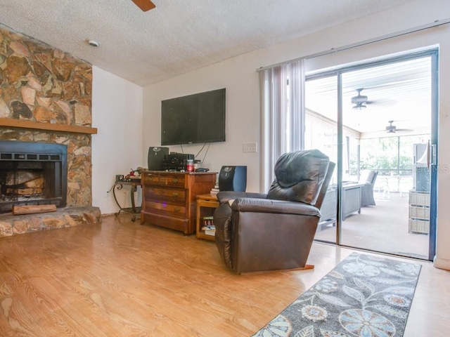 1610 Sanderling Ct, Brandon, FL 33511 - living room featuring ceiling fan, lofted ceiling, a textured ceiling, wood finished floors, and a fireplace