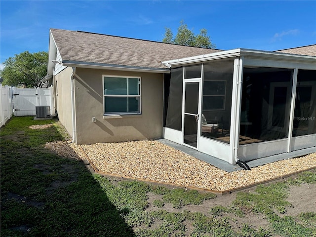 7301 Mitchell Ranch Rd, New Port Richey, FL 34655 - rear view of property with a shingled roof, a sunroom, stucco siding, and a gate
