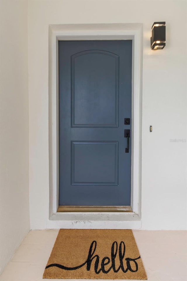 245 Grove Cir N, Dunedin, FL 34698 - view of exterior entry featuring stucco siding