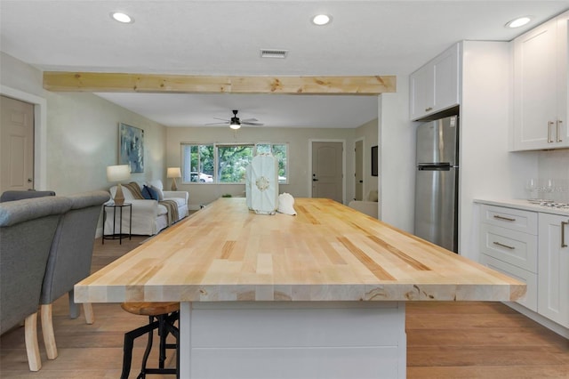 245 Grove Cir N, Dunedin, FL 34698 - kitchen featuring freestanding refrigerator, open floor plan, white cabinets, wood finished floors, and beam ceiling
