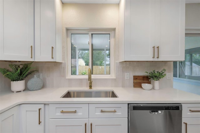 245 Grove Cir N, Dunedin, FL 34698 - kitchen featuring dishwasher, white cabinets, backsplash, and light countertops