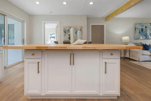 245 Grove Cir N, Dunedin, FL 34698 - kitchen with open floor plan, recessed lighting, light wood-style floors, wood counters, and white cabinetry