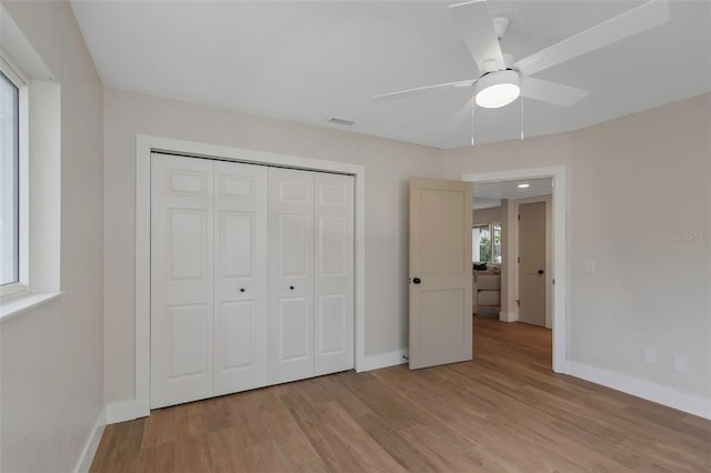 245 Grove Cir N, Dunedin, FL 34698 - unfurnished bedroom with light wood-style flooring, a closet, and ceiling fan