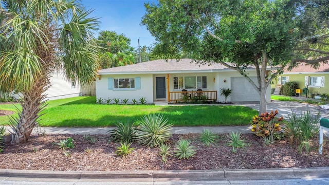 245 Grove Cir N, Dunedin, FL 34698 - ranch-style home with covered porch, an attached garage, a front yard, stucco siding, and driveway